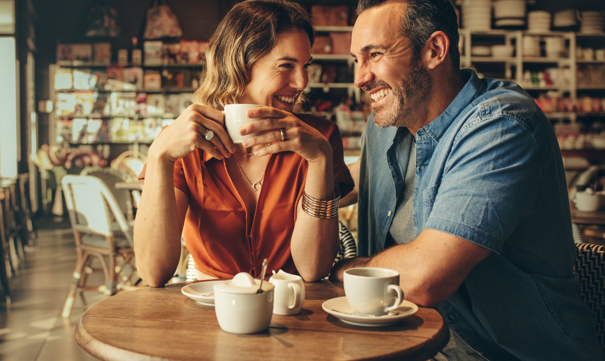 Couple having coffee, talking and smiling.